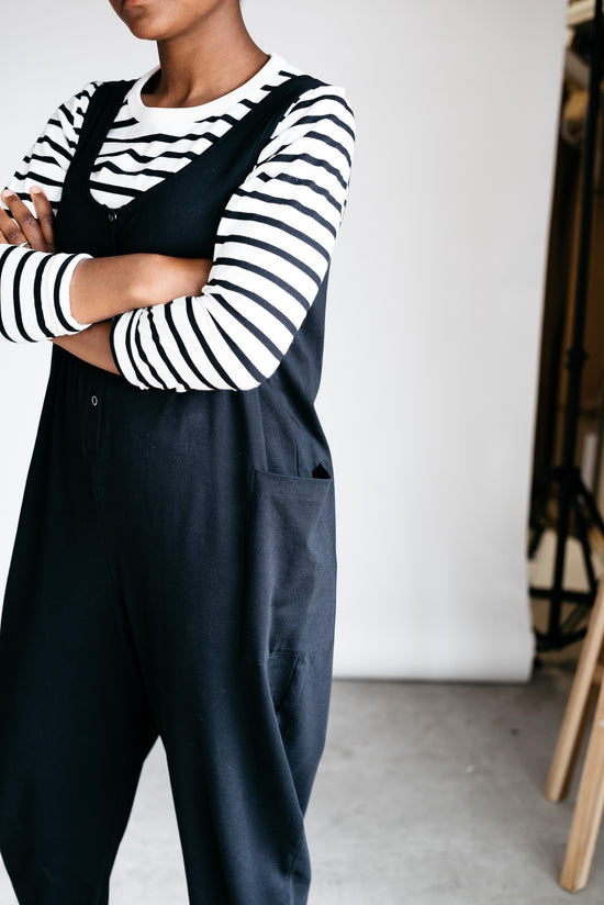 model wears black jersey poppy jumpsuit